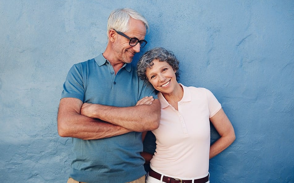 senior couple standing outdoors smiling at the camera