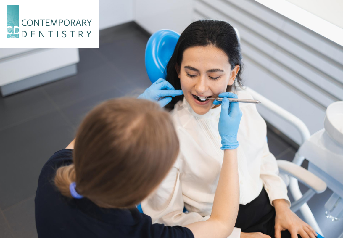 Woman sitting in dental chair at medical center while professional doctor checks her teeth